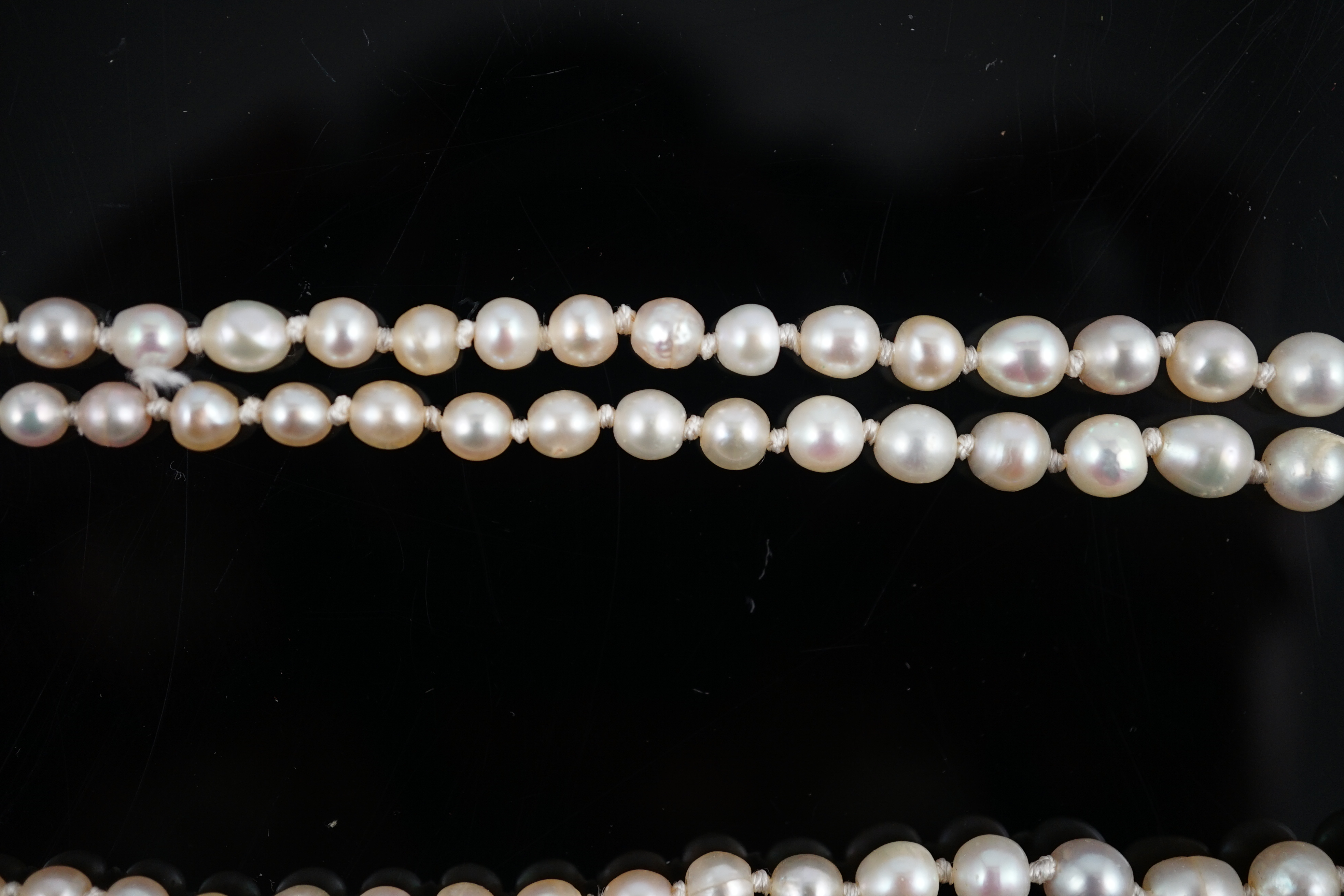 A twin strand graduated cultured pearl necklace, with gold and six stone diamond set rectangular clasp